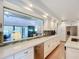 Modern kitchen with white cabinetry, a stainless steel dishwasher, countertops, and views into the living room at 2040 N Nemo Dr, Deltona, FL 32725