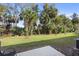 Grass backyard with mature trees and a patio at 2353 Carrabelle Way, Sanford, FL 32771