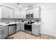 Modern gray kitchen with stainless steel appliances and white countertops at 2353 Carrabelle Way, Sanford, FL 32771