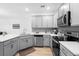 Modern gray kitchen with stainless steel appliances and ample counter space at 2353 Carrabelle Way, Sanford, FL 32771