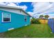 Side view of a teal house with a well-maintained lawn at 241 Ponce De Leon Dr, Ormond Beach, FL 32176