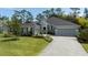 Gray two-story house with a three-car garage and a well-manicured lawn at 2423 Wild Turkey Creek Ln, Port Orange, FL 32128
