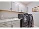 Bright laundry room with modern washer, dryer, and cabinets at 2423 Wild Turkey Creek Ln, Port Orange, FL 32128