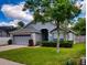 Single-story house with gray exterior, neatly landscaped yard, and a two-car garage at 2911 Wild Pepper Ave, Deltona, FL 32725