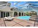Stunning screened-in pool area with brick pavers, covered seating, and lush landscaping creating a private oasis at 3548 Tuscany Reserve Blvd, New Smyrna Beach, FL 32168