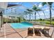 Inviting pool area with lounge chairs, palm trees, and a screened enclosure for year-round enjoyment at 3548 Tuscany Reserve Blvd, New Smyrna Beach, FL 32168