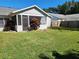 Spacious backyard with grassy lawn and screened porch at 3566 Red Pontiac Dr, Port Orange, FL 32129