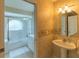 Bathroom with pedestal sink, large mirror, and tub shower combo at 3605 Galway Ln, Ormond Beach, FL 32174