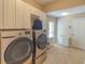 Laundry room with washer, dryer, cabinets, and extra storage at 3605 Galway Ln, Ormond Beach, FL 32174