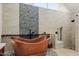 Relaxing bathroom with copper tub, stone feature wall, and walk-in shower at 4 Lake Vista Way, Ormond Beach, FL 32174