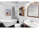 Updated bathroom with clawfoot tub, pedestal sink, and dark tile floor at 448 E Church St, Deland, FL 32724