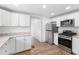 Modern kitchen with white shaker cabinets, granite counters, and stainless steel appliances at 448 E Church St, Deland, FL 32724