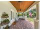 Front porch with brick floor, white chairs, and hanging planter boxes at 509 Faulkner St, New Smyrna Beach, FL 32168