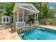 Charming poolside pergola with seating and fountain at 509 Faulkner St, New Smyrna Beach, FL 32168