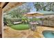 Landscaped backyard with patio, table, and umbrella at 511 W Minnesota Ave, Deland, FL 32720