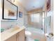 Well-lit bathroom featuring a bathtub with glass enclosure and neutral tile at 55 Fairway Dr # 3D, Debary, FL 32713