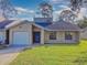 Tan one-story home with a white garage door and green lawn at 55 Fairway Dr # 3D, Debary, FL 32713