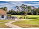 Scenic golf course view with lush green grass, golf carts, mature trees, and an American flag waving in the breeze at 55 Fairway Dr # 3D, Debary, FL 32713