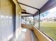 View of the enclosed lanai featuring tile flooring and screen windows overlooking the backyard and blue sky at 55 Fairway Dr # 3D, Debary, FL 32713