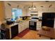 Galley kitchen with white cabinets and black appliances at 575 Lantern Ln, Orange City, FL 32763