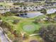 Aerial view of a golf course community with houses and a pond at 10025 Scottish Pines Ct, Orlando, FL 32832