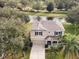 Two-story house with a two-car garage, situated on a tree-lined street near a lake at 10025 Scottish Pines Ct, Orlando, FL 32832