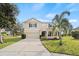Two-story house with tan exterior, black shutters, and a two-car garage at 10025 Scottish Pines Ct, Orlando, FL 32832