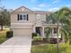 Two-story house with a two-car garage and palm trees in front at 10025 Scottish Pines Ct, Orlando, FL 32832