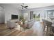 Staged living room featuring wood-look flooring, a ceiling fan, and sliding doors to the outdoors at 10025 Scottish Pines Ct, Orlando, FL 32832