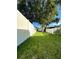 Large backyard with a white fence and a large tree at 12 Peruvian Ln, Ormond Beach, FL 32174