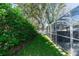Large backyard with grassy area, screened enclosure, and lush landscaping at 12 Peruvian Ln, Ormond Beach, FL 32174