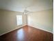 Bright bedroom features sleek wood floors, a ceiling fan, and natural light from the window at 12 Peruvian Ln, Ormond Beach, FL 32174