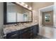 Bathroom with double sinks, granite countertop, and a large mirror, creating a functional and elegant space at 1278 Chessington Cir, Lake Mary, FL 32746