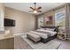 Modern bedroom with neutral walls, a ceiling fan, carpet, a mounted TV, and natural light through windows at 1278 Chessington Cir, Lake Mary, FL 32746