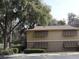 Tan building with brown roof and shutters, surrounded by trees and landscaping at 130 Jasmine Woods Ct # 15C, Deltona, FL 32725