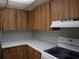 Kitchen with wood cabinets, white appliances, and light gray countertops at 130 Jasmine Woods Ct # 15C, Deltona, FL 32725