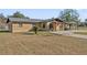 Tan single story house with carport and large yard at 1701 N Stone St, Deland, FL 32720