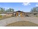 Tan single story house with wooden pillars and attached carport at 1701 N Stone St, Deland, FL 32720