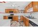 Full view of kitchen with wood cabinets and appliances at 1701 N Stone St, Deland, FL 32720