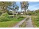 Long, winding driveway leading to a charming home nestled amongst mature trees and lush landscaping at 2170 Wilmhurst Rd, Deland, FL 32720