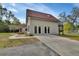 Back exterior view of the home featuring a large garage with glass doors, an upper level balcony, and a paved driveway at 2170 Wilmhurst Rd, Deland, FL 32720