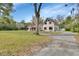 Wide shot of the home's exterior, featuring an attached garage, ample parking, and a large yard at 2170 Wilmhurst Rd, Deland, FL 32720