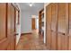 Hallway features terra cotta tile flooring, wood accents, built-in shelves, and natural light at 2170 Wilmhurst Rd, Deland, FL 32720