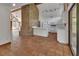 Open concept kitchen with brick fireplace, white cabinetry, and terra cotta tile flooring at 2170 Wilmhurst Rd, Deland, FL 32720