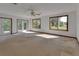 Spacious living room with neutral carpet, ceiling fan, and large windows providing natural light at 2170 Wilmhurst Rd, Deland, FL 32720