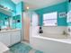 Bathroom with a bathtub, shower, and teal colored walls at 2508 Balmoral Dr, Kissimmee, FL 34744