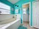 Bathroom with bathtub and teal colored walls at 2508 Balmoral Dr, Kissimmee, FL 34744