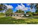 House exterior showcasing a light blue home with a white garage door and well-manicured lawn at 2530 E New York Ave, Deland, FL 32724