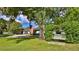 Landscaped front yard with a white swing bench under a large oak tree at 2530 E New York Ave, Deland, FL 32724