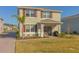 Two-story house with red shutters, double doors, and a landscaped yard, near a pond at 3033 Meleto Blvd, New Smyrna Beach, FL 32168